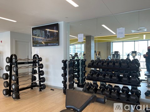 A gym with a variety of equipment including dumbbells and weight machines.