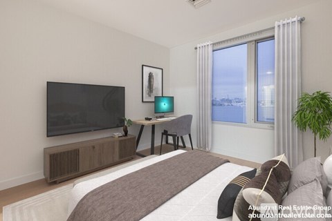 A bedroom with a large bed, a flat screen TV, a desk with a computer, and a window with a view of the city.