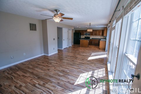 A room with wooden flooring and a ceiling fan.