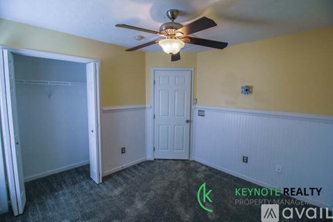 A room with a ceiling fan and a door.