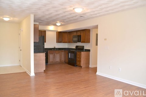 A kitchen with wooden cabinets and black appliances.