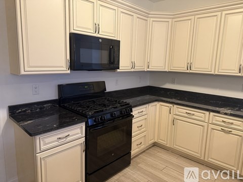 A kitchen with black countertops and white cabinets.