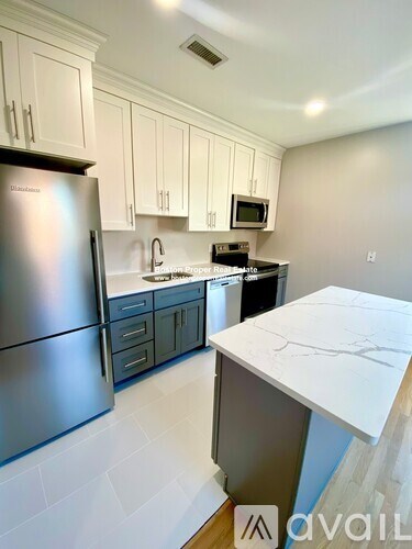 A kitchen with a stainless steel refrigerator and a white countertop.
