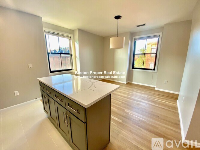 A kitchen with a countertop, cabinets, and a window.