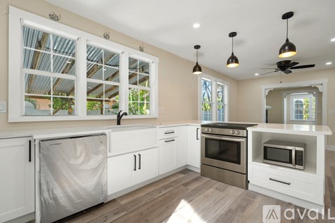 A kitchen with white cabinets and a stainless steel refrigerator.