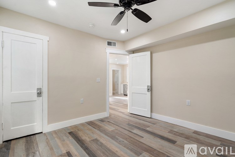 A room with a ceiling fan and wooden flooring.
