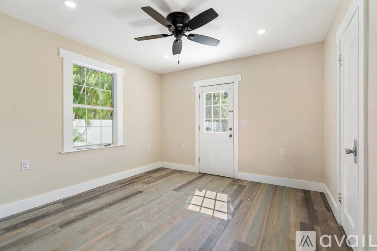 A room with a ceiling fan and wooden flooring.