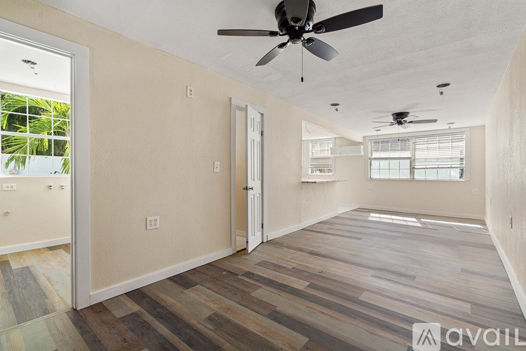 A room with a ceiling fan and wooden flooring.