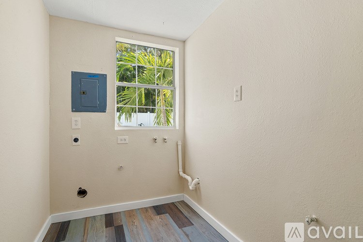 A room with a window and a wooden floor.