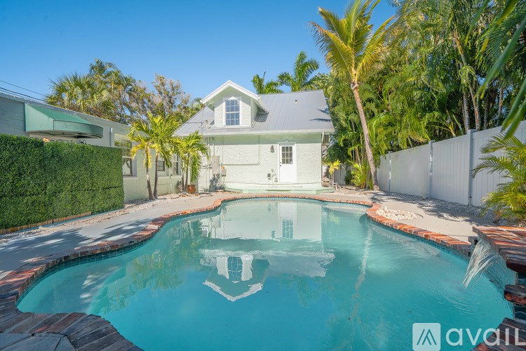 A house with a pool in front of it.