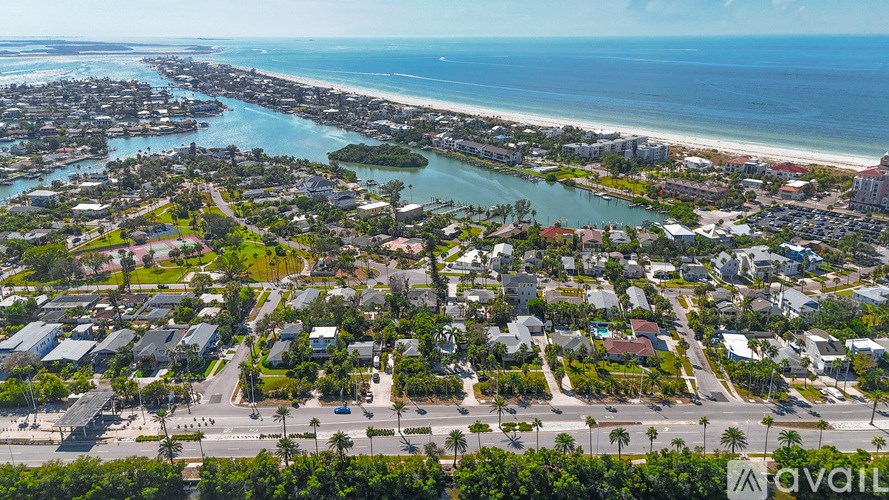 A bird's eye view of a residential area with a beach in the background.