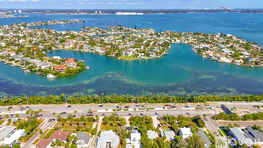 A bird's eye view of a residential area with a body of water in the foreground.