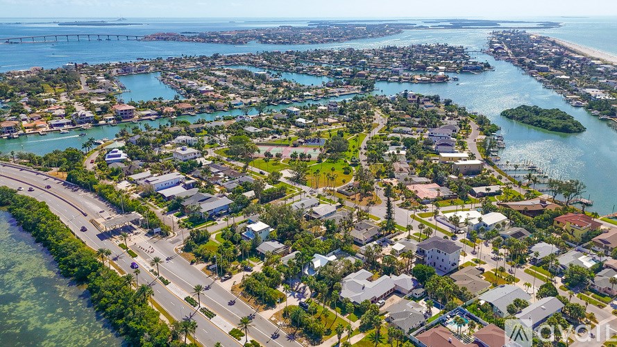 A bird's eye view of a residential area with houses, roads, and a body of water.