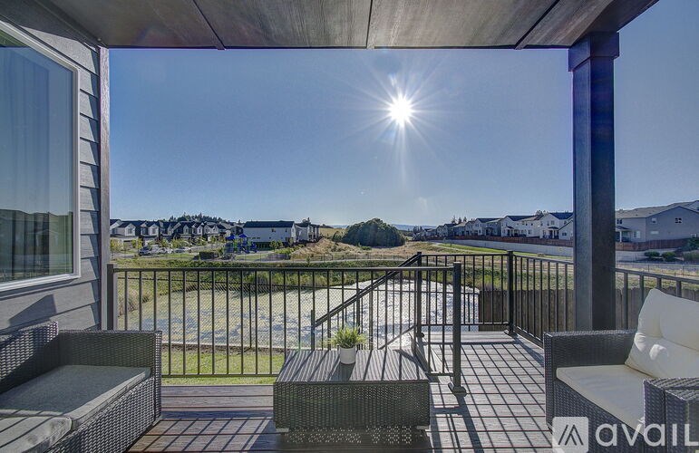 A balcony with a view of a field and houses.