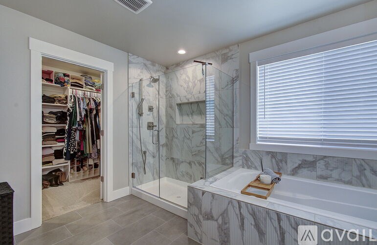 A bathroom with a walk-in shower and a marble countertop.