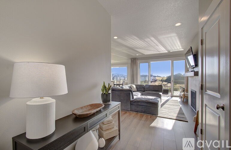 A well-lit living room with a view of the ocean.