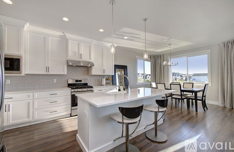 A modern kitchen with white cabinets and a large island.