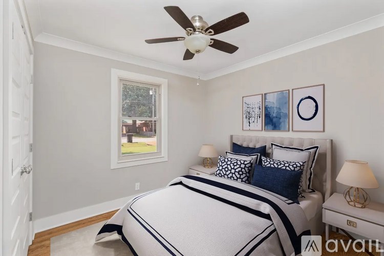 A bedroom with a large bed and a ceiling fan.