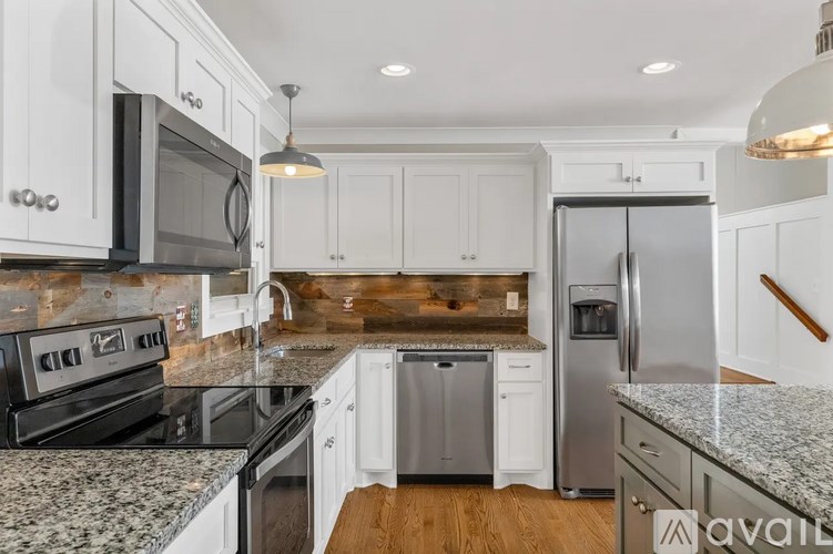 A kitchen with white cabinets and a granite countertop.