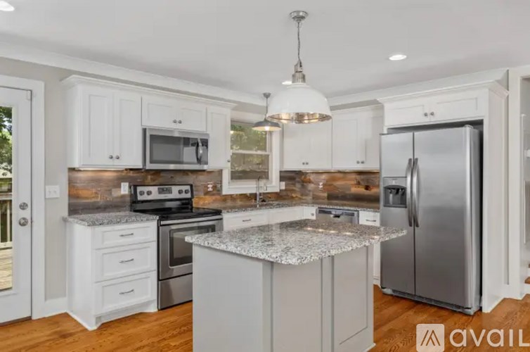 A kitchen with a granite countertop and stainless steel appliances.