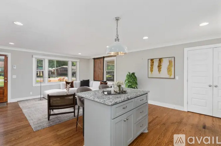 A kitchen with a granite countertop and a dining table with chairs.