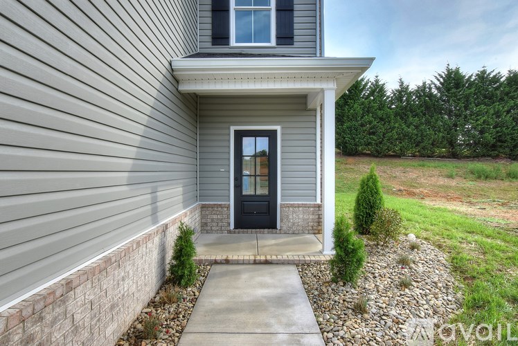 A house with a grey siding and a black door.