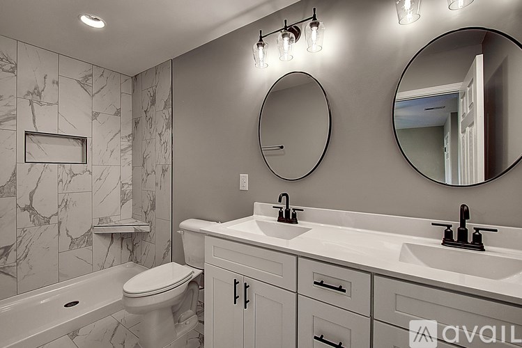 A bathroom with a marble wall and a white toilet.