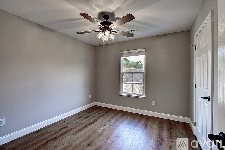 A room with a ceiling fan and a window.