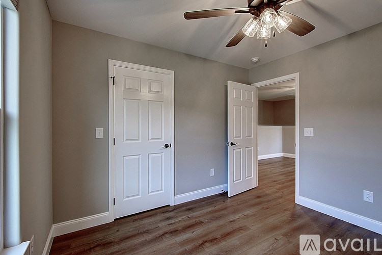 A room with a ceiling fan and two doors.