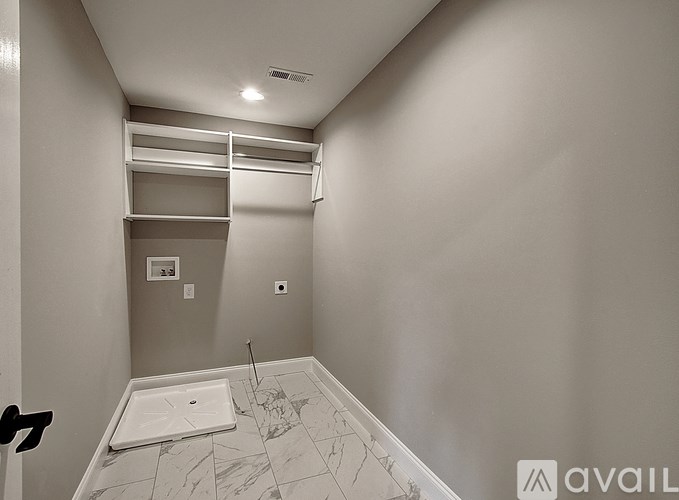 A bathroom with a marble floor and a walk-in shower.