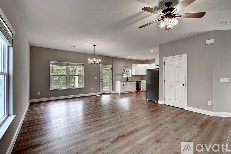 A spacious living room with wood flooring and a ceiling fan.