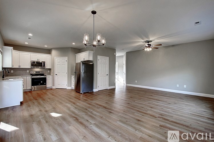 A kitchen with white cabinets and a wooden floor.