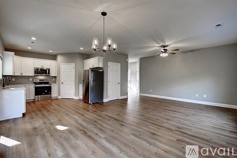A kitchen with white cabinets and a wooden floor.