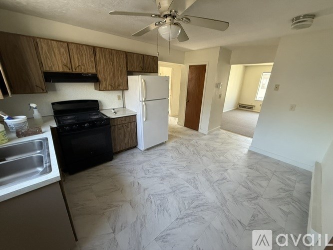 A kitchen with a black stove top oven and a white refrigerator.