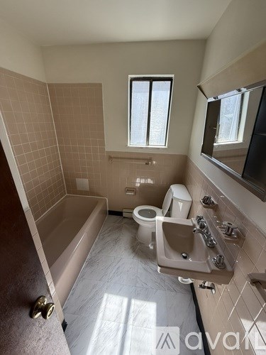 A bathroom with a tub, toilet, and sink.