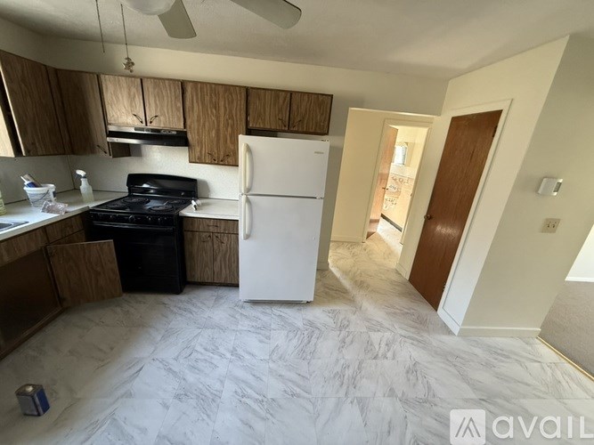 A kitchen with a white fridge and black stove top.