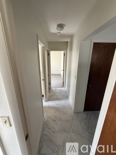 A long hallway with a door on the right.