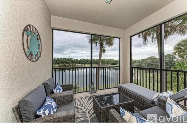 A balcony with a table and chairs overlooking a body of water.