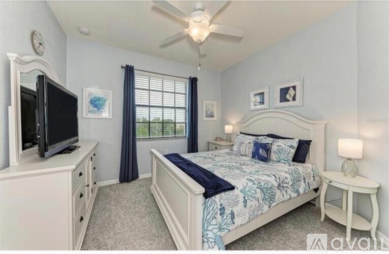 A bedroom with a large bed, a flat screen TV, and a ceiling fan.