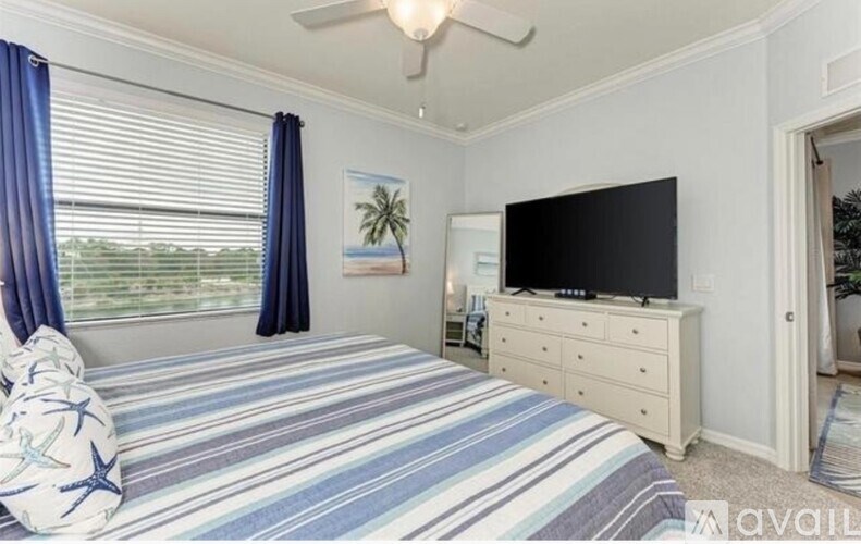 A bedroom with a bed, dresser, and television.