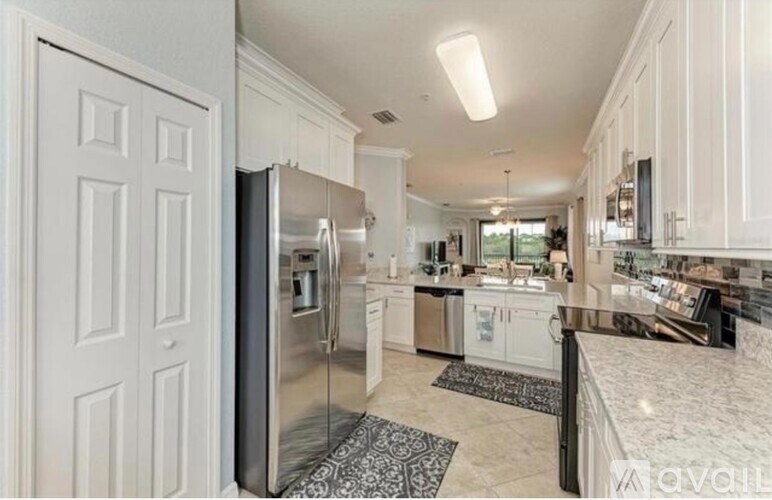 A modern kitchen with a refrigerator, sink, and cabinets.