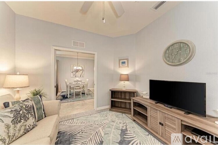 A living room with a couch, a television, and a rug.
