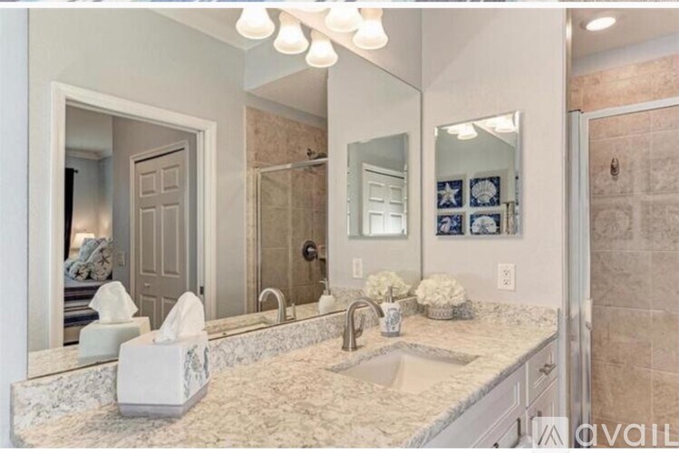 A bathroom with a marble countertop and a large mirror.
