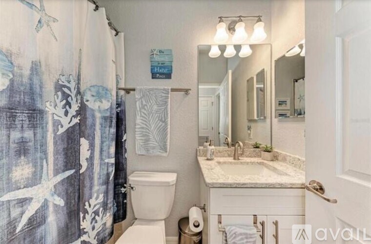 A bathroom with a toilet, sink, and shower curtain.