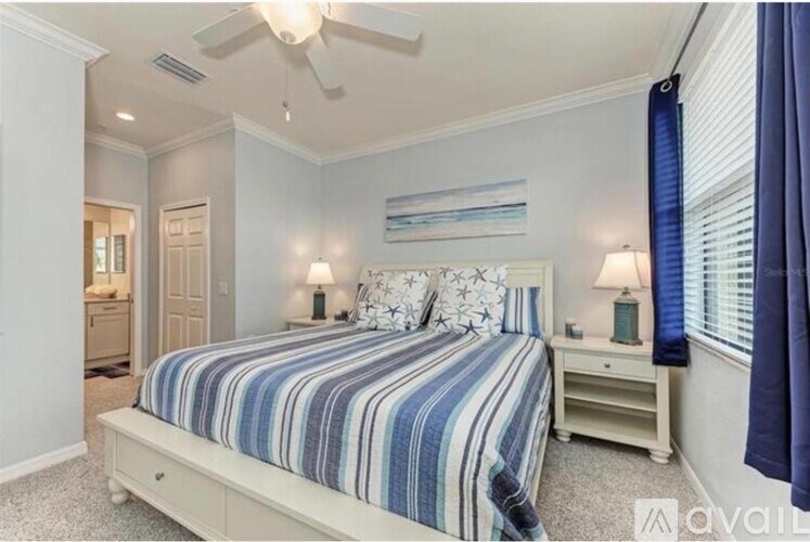 A bedroom with a bed, nightstand, and a ceiling fan.