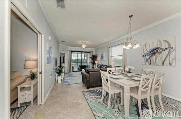 A dining room with a white table and chairs.