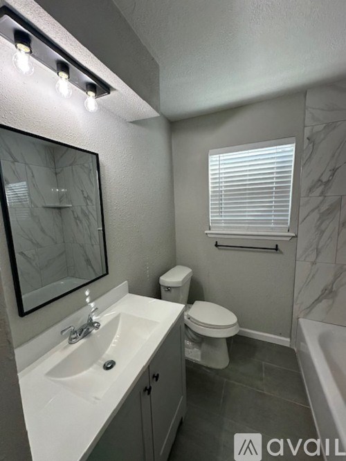 A bathroom with a sink, toilet, and bathtub.