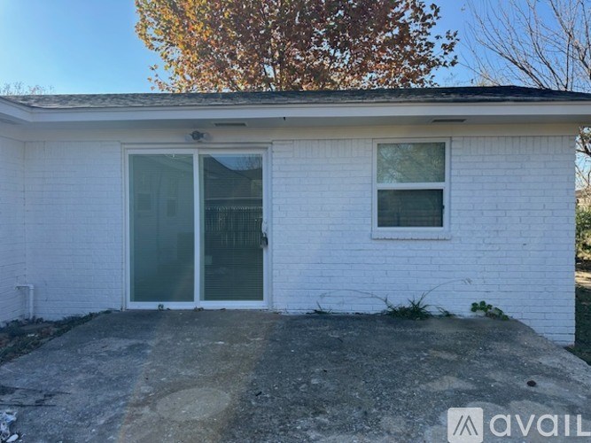 A small white house with a glass door and a window is available for rent.