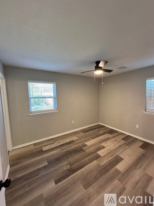 A room with wooden flooring and a ceiling fan.