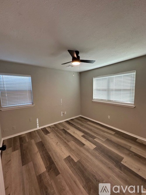 A room with wooden flooring and a ceiling fan.